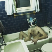 man in a bath and his head is a cat's head